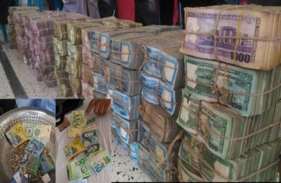 Bundles of counted and organized cash neatly stacked and tied in large piles after sorting.